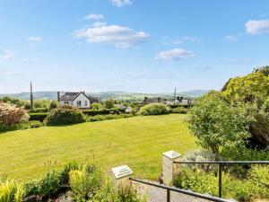 a view from the garden of a house with a large lawn at The Coach House- Uk45660 in Bishops Castle