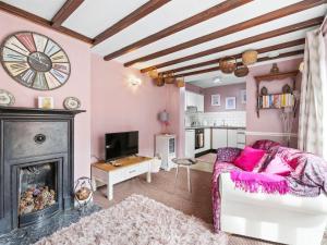 a living room with a fireplace and pink walls at The Coach House- Uk45660 in Bishops Castle