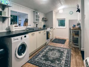 a kitchen with a sink and a washing machine at South Lochs in Marvig