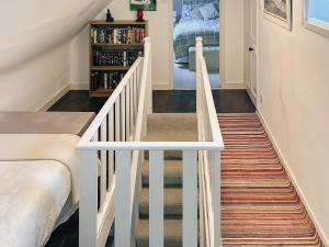 a stairway leading up to a bedroom with a bed at South Lochs in Marvig