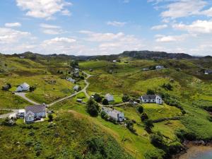 an aerial view of a house on a grassy hill at South Lochs in Marvig