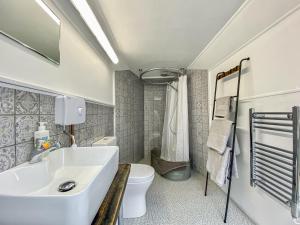 a bathroom with a white sink and a toilet at Ivy Shepherds Hut - Uk45590 in Seend
