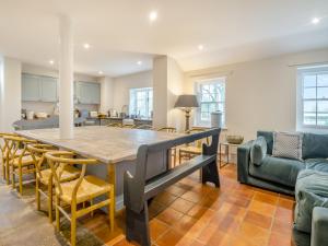 a kitchen and living room with a table and chairs at Abbey Barn Farmhouse in Wereham