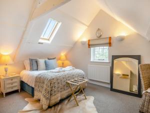 a bedroom with a bed and a mirror at Abbey Barn Farmhouse in Wereham