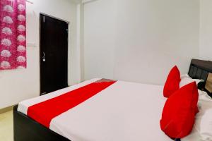 a bedroom with a red and white bed with red pillows at OYO Flagship Shine Hotel in Chinhat
