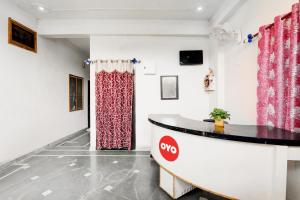 a room with a counter and a red curtain at OYO Flagship Shine Hotel in Chinhat