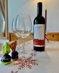 a bottle of wine and two wine glasses on a table at Central Kitz Apartments in Kitzbühel