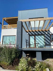 a house with a balcony with two benches on it at Chalet playa hermosa in Pichilemu