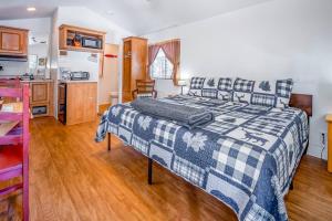 a bedroom with a blue and white bed and a kitchen at The Blue Fox Cabin #8 at Blue Spruce RV Park & Cabins in Tuckerville +13 photos