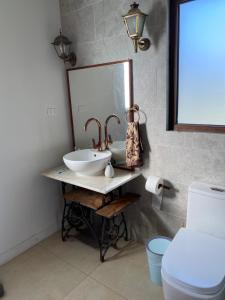 une salle de bain avec un lavabo et un miroir et des toilettes dans l'établissement Chalet playa hermosa, à Pichilemu 28 autres photos