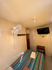 a bedroom with a bed with a fan on the wall at Hotel RODEY in Huaquillas