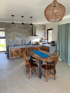 une cuisine avec une table et des chaises dans une cuisine dans l'établissement Chalet playa hermosa, à Pichilemu