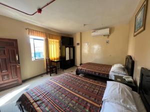 a hotel room with two beds and a window at Hotel RODEY in Huaquillas