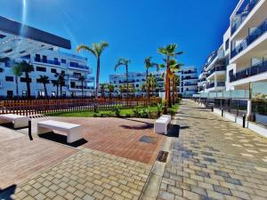 a brick walkway with benches in front of buildings at PUSHE Playa Granada Beach & Golf 23 in Motril