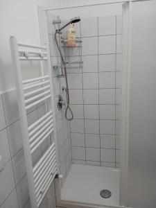 a shower in a white tiled bathroom at Sweet home in Isnello