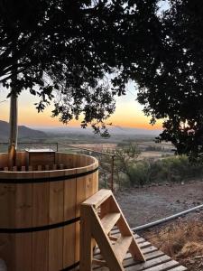 a wooden hot tub sitting under a tree at Cabaña del Boldo, naturaleza y vista al valle. in Curicó