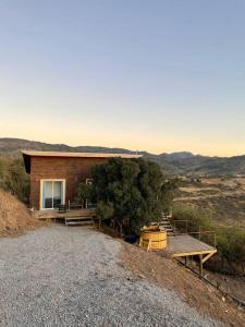 Cabaña de madera con mesa de picnic y árbol en Cabaña del Boldo, naturaleza y vista al valle. en Curicó