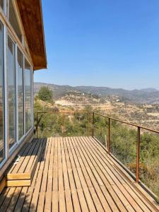 una terraza de madera con vistas a las montañas en Cabaña del Boldo, naturaleza y vista al valle. en Curicó