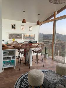 cocina con sillas y mesa con vistas en Cabaña del Boldo, naturaleza y vista al valle., en Curicó