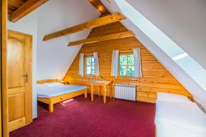 a attic room with two beds and a table at Holiday Raj in Bešeňová