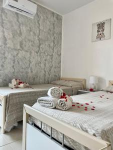 een slaapkamer met 2 bedden en handdoeken bij B&b il cuore di Kroton in Crotone