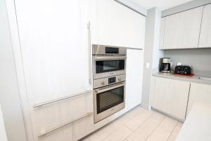 a kitchen with white cabinets and a stainless steel oven at Diamond In The Sky in Hollywood
