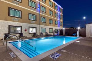 a swimming pool in front of a building at Best Western Plus Arlington North in Arlington