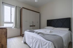 ein Schlafzimmer mit einem großen Bett und einem Fenster in der Unterkunft Apto com churrasqueira privativa Itapema-SC CPE203 in Itapema