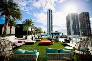 a patio with lounge chairs and palm trees and buildings at Diamond In The Sky in Hollywood