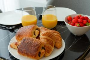 a table with two plates of pastries and a bowl of fruit at Designer apartment on St Louis Island in Paris - Welkeys in Paris