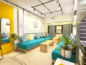 sala de estar con sofá y mesa en Locomo Express - Stay Work Eat, en Bombay