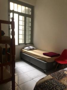 a small bedroom with a bed and a window at Hostel Bahia in Porto Alegre