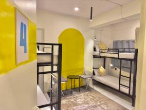 Cette chambre dispose de 2 lits superposés et d'un mur jaune. dans l'établissement Locomo Express - Stay Work Eat, à Mumbai