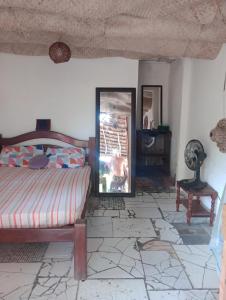 Schlafzimmer mit einem Bett und einem Spiegel in der Unterkunft Suíte beija-flor in Camaçari