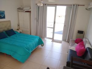 1 dormitorio con cama, sofá y ventana en Juana I en Villa Elisa