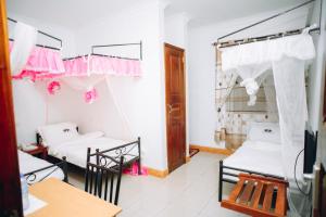 Cette chambre comprend 2 lits et une table. dans l'établissement Arusha Giraffe Lodge, à Arusha