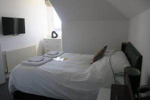 a bedroom with a bed with two towels on it at Cumbrae View House (Licence no NA00109F) in Largs