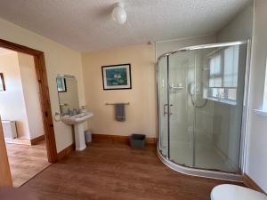 ein Bad mit einer Dusche und einem Waschbecken in der Unterkunft House in Glenties in Glenties