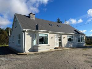 a small white house with a roof at House in Glenties in Glenties