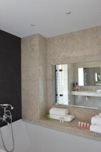 uma casa de banho com um espelho e um lavatório em Grand Hotel de L'Océan em Le Croisic