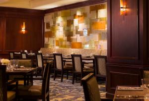 un comedor con mesas, sillas y una pared en The Westin Pittsburgh en Pittsburgh