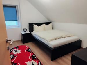 a small bedroom with a bed with a red rug at Ferienwohnung Fabian in Stainach