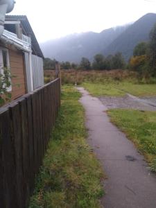 a sidewalk next to a fence next to a house at Cabaña carmencita in Puerto Puyuhuapi