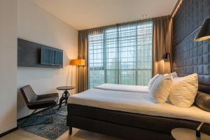 een hotelkamer met een bed en een raam bij Leonardo Hotel Groningen in Groningen