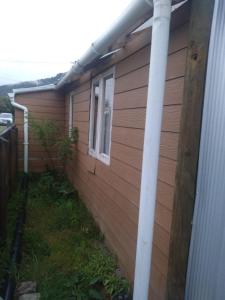 eine Seite eines Hauses mit einer Stange in der Unterkunft Cabaña carmencita in Puerto Puyuhuapi
