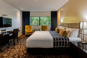 una camera d'albergo con un letto e una scrivania di The George a Christchurch