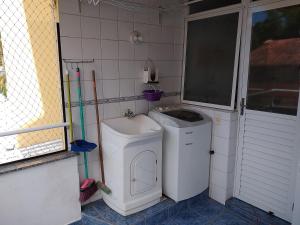 a bathroom with a washing machine and a washer at Solar Diamantina Apartamentos in Florianópolis