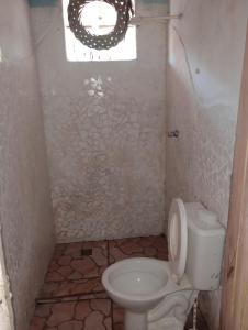 uma pequena casa de banho com um WC e uma janela em Suíte beija-flor em Camaçari