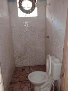 a small bathroom with a toilet and a window at Suíte Beija-flor in Camaçari
