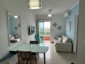 een woonkamer met een tafel en een bank bij FLAT RIVIERA COM AR A 150 m DA PRAIA ! in Riviera de São Lourenço